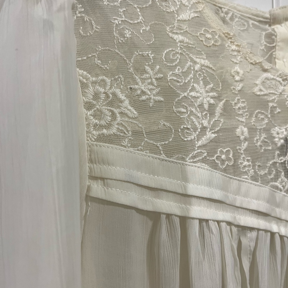 Flowy cream dress top with ruched sleeves and buttoned upper back.